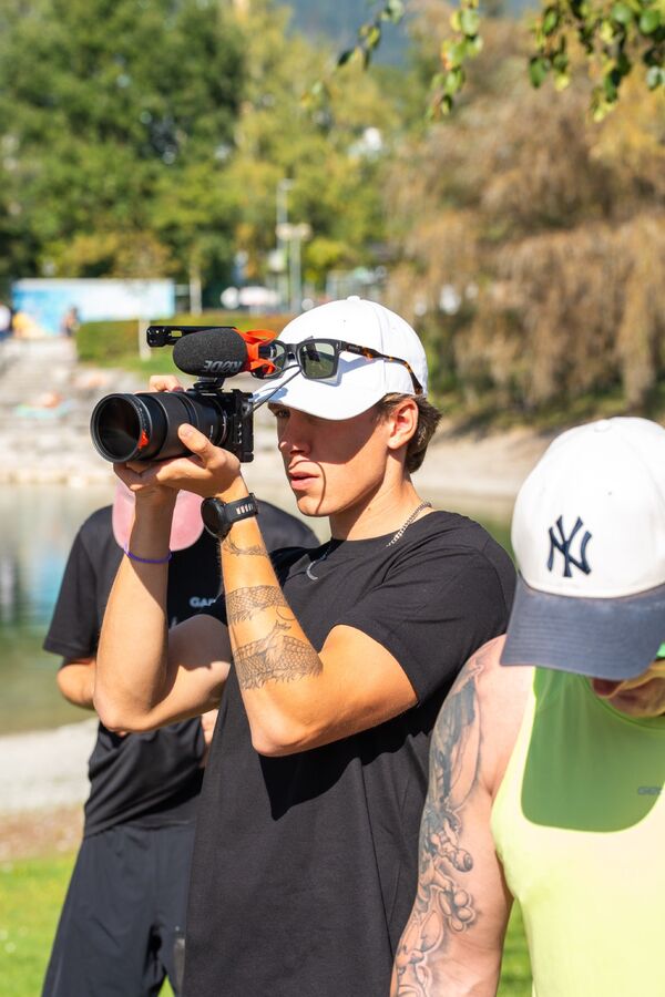 Fabian filmt mit Kamera und Mikrofon bei einem Lauf-Event